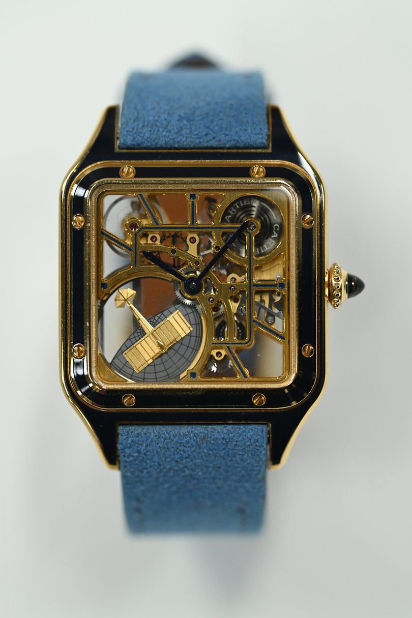 Cartier Santos-Dumont Skeleton in yellow gold with black lacquer, a gold aeroplane bridge across the openworked movement, on a blue strap